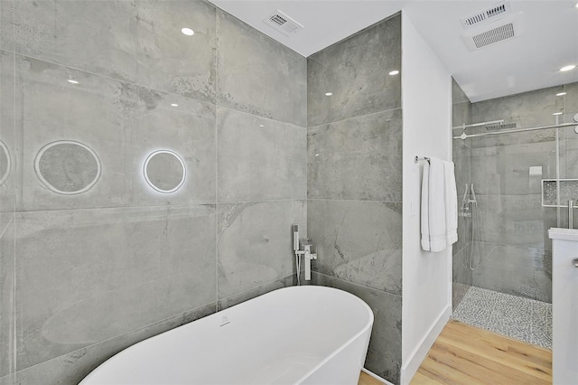 bathroom with tile walls, hardwood / wood-style flooring, and independent shower and bath