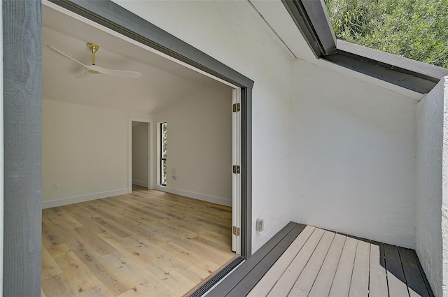 entrance to property featuring a balcony and ceiling fan