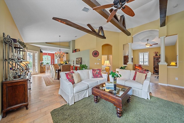 living room featuring vaulted ceiling with beams, plenty of natural light, decorative columns, and light hardwood / wood-style flooring