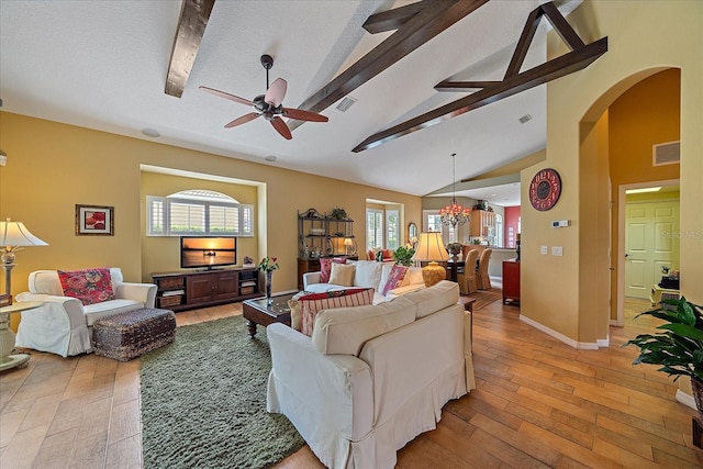 living room with ceiling fan with notable chandelier, a textured ceiling, beam ceiling, high vaulted ceiling, and light hardwood / wood-style floors