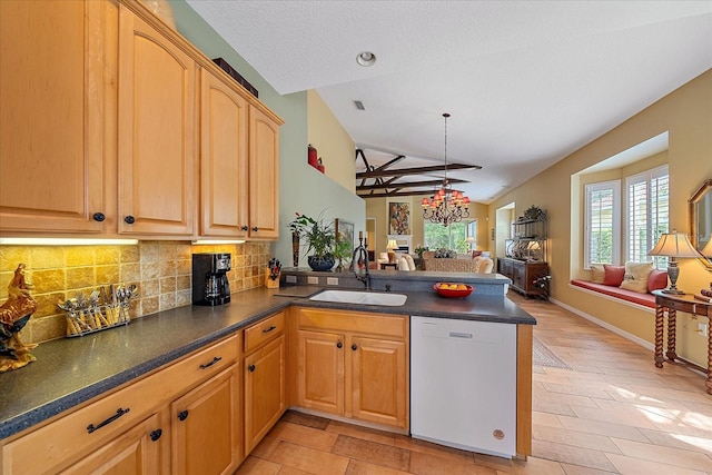 kitchen featuring tasteful backsplash, kitchen peninsula, sink, and white dishwasher