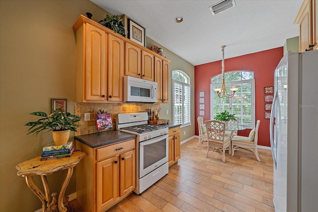 kitchen with white appliances, backsplash, decorative light fixtures, a notable chandelier, and light hardwood / wood-style floors