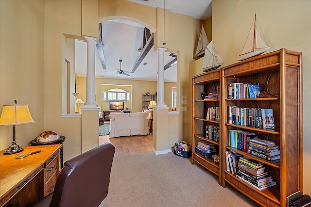 home office with decorative columns, ceiling fan, and light carpet