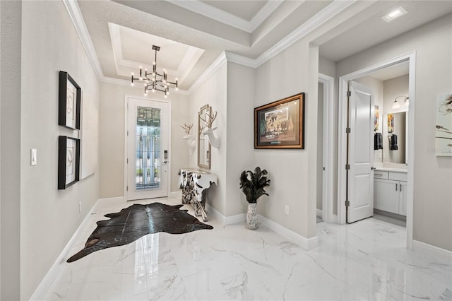 foyer entrance featuring a raised ceiling, an inviting chandelier, and ornamental molding