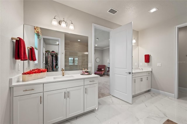 bathroom featuring vanity, a shower with shower door, and a textured ceiling