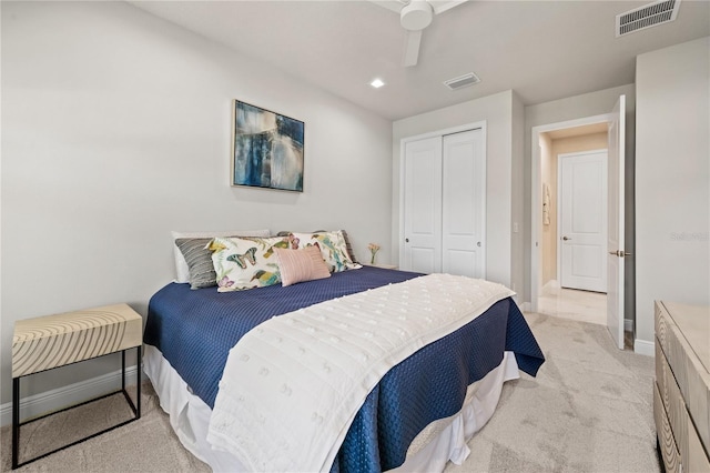 bedroom with a closet, ceiling fan, and light colored carpet