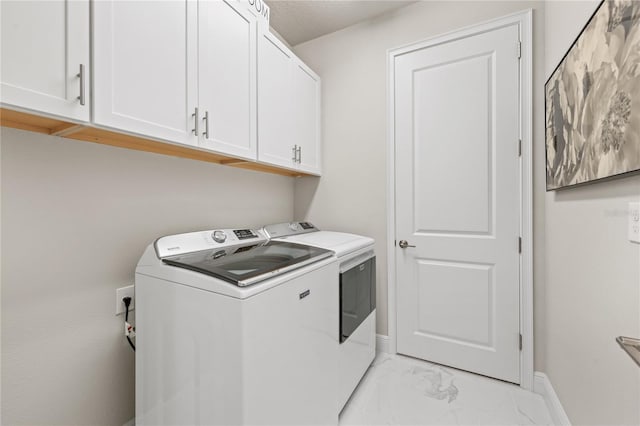 laundry room with washer and clothes dryer and cabinets