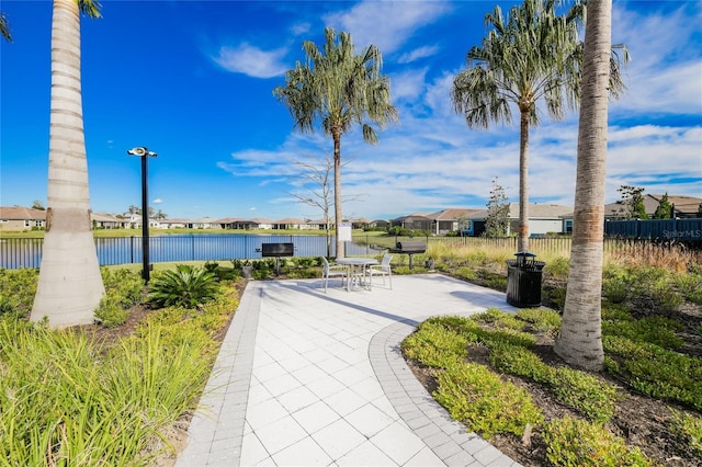 view of property's community with a water view and a patio area