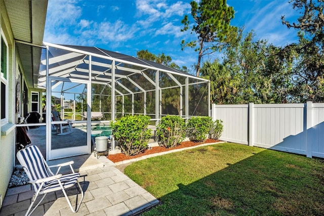 view of yard with glass enclosure and a patio area