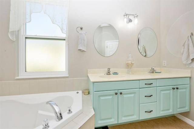 bathroom with vanity, tile patterned floors, and tiled tub