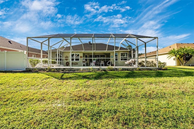 back of property featuring a lanai and a yard