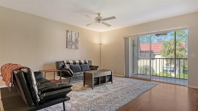 living room featuring a textured ceiling, hardwood / wood-style flooring, and ceiling fan