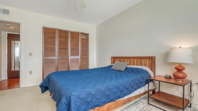 carpeted bedroom with ceiling fan and a closet