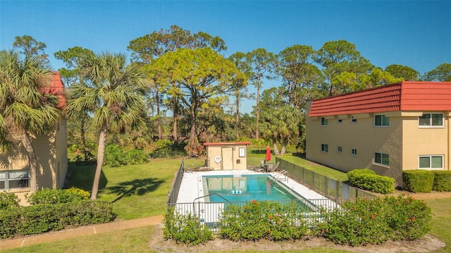 view of swimming pool with a yard and a storage shed