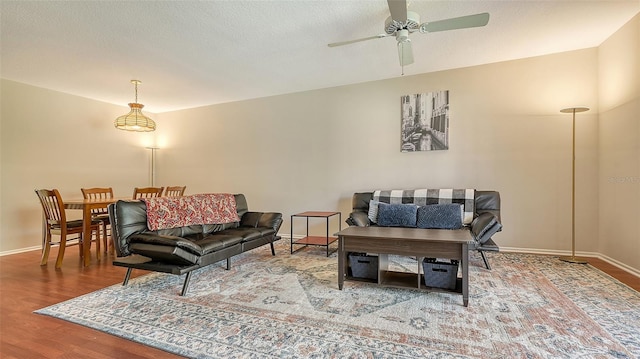 living room featuring ceiling fan, a textured ceiling, and hardwood / wood-style flooring