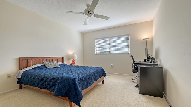 bedroom with a textured ceiling, light colored carpet, and ceiling fan