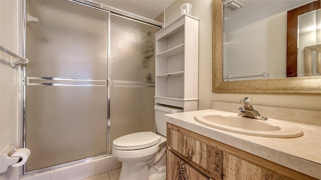 bathroom with toilet, vanity, tile patterned floors, and a shower with door