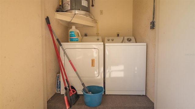 clothes washing area with washer and clothes dryer and dark colored carpet