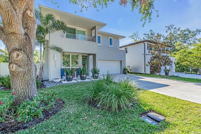 view of front of home featuring a balcony, a garage, concrete driveway, and stucco siding