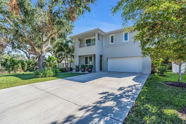 view of front of house with a balcony, a garage, and a front lawn