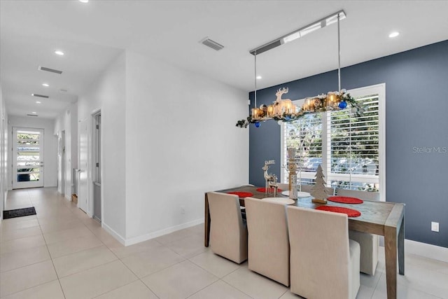 dining room with light tile patterned floors and a notable chandelier