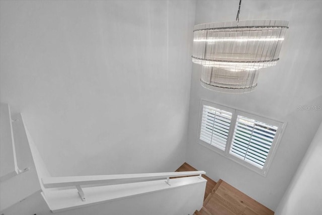 stairway featuring hardwood / wood-style flooring and a chandelier