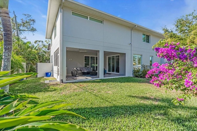 back of property with a patio area and a yard