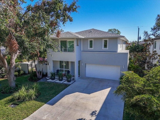 view of front of house with a balcony, a front yard, and a garage