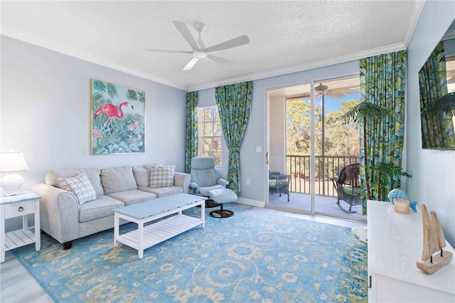 living room featuring wood-type flooring, ornamental molding, a healthy amount of sunlight, and ceiling fan