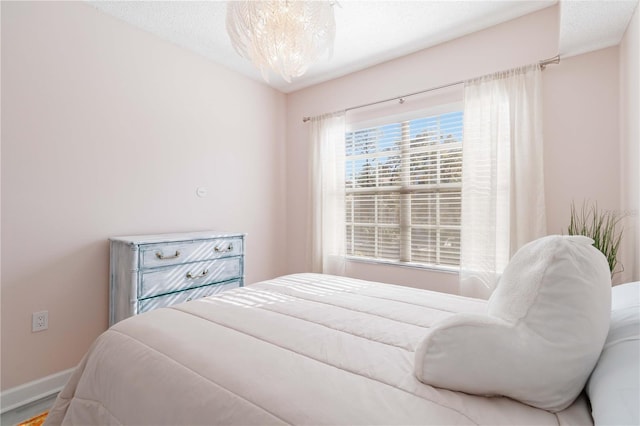 bedroom with a textured ceiling and a chandelier