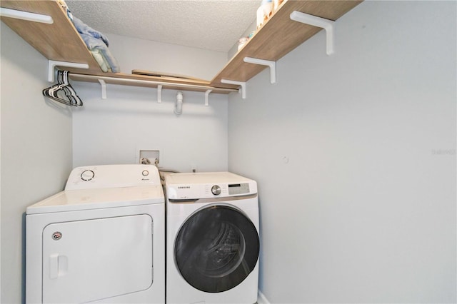 washroom with independent washer and dryer and a textured ceiling