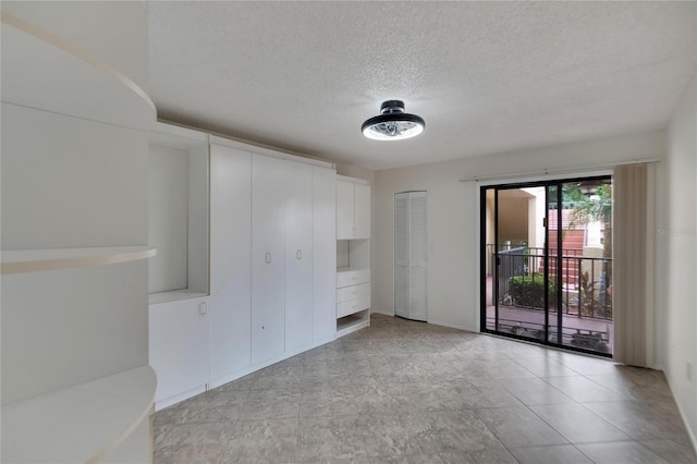 empty room with light tile patterned floors and a textured ceiling