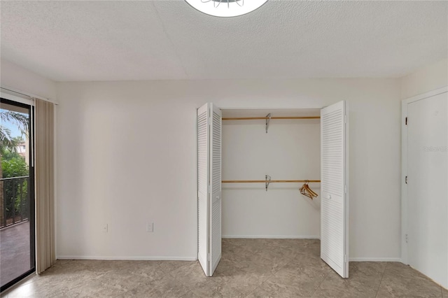 unfurnished bedroom with access to exterior, a closet, and a textured ceiling