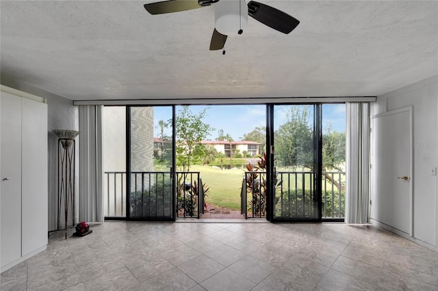 unfurnished room with ceiling fan, plenty of natural light, and expansive windows