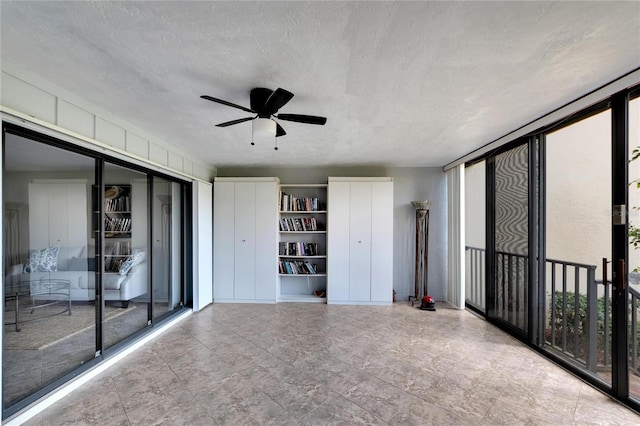 empty room with a textured ceiling and ceiling fan