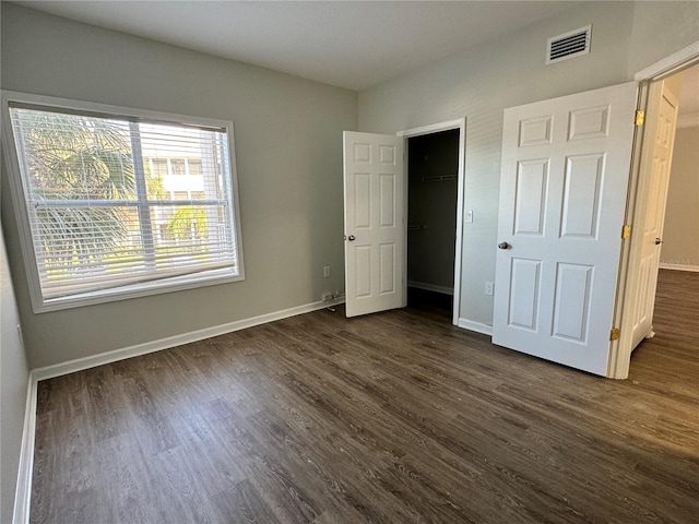 unfurnished bedroom featuring dark hardwood / wood-style floors and a closet