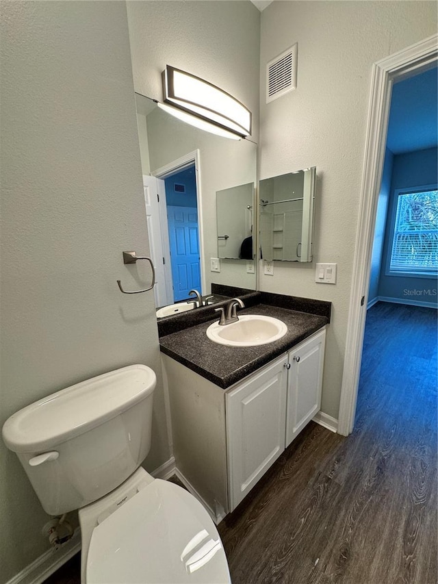 bathroom with vanity, wood-type flooring, and toilet