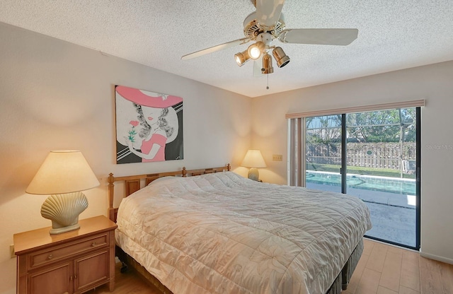 bedroom with access to exterior, ceiling fan, light hardwood / wood-style floors, and a textured ceiling