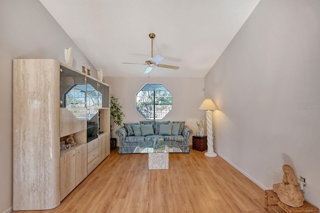 living room featuring ceiling fan, light hardwood / wood-style floors, and lofted ceiling