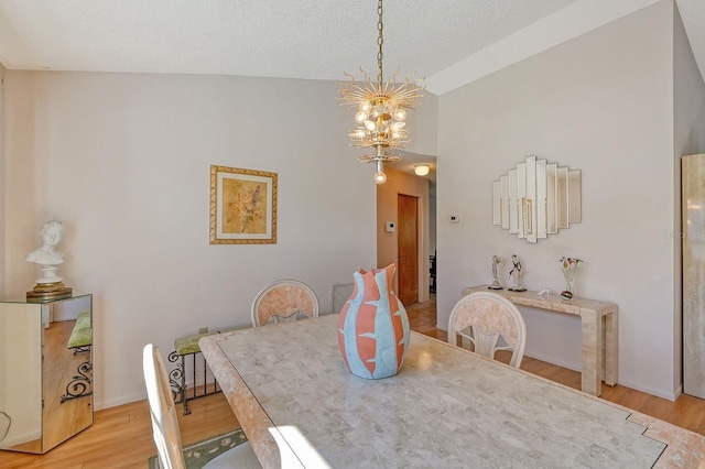 dining area with light hardwood / wood-style flooring, vaulted ceiling, and a notable chandelier