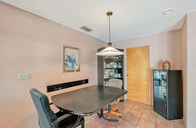 tiled dining room with a textured ceiling