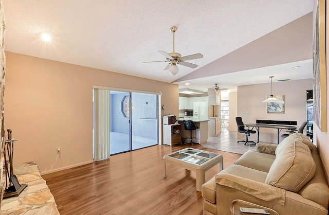 living room with a textured ceiling, ceiling fan, light hardwood / wood-style flooring, and lofted ceiling