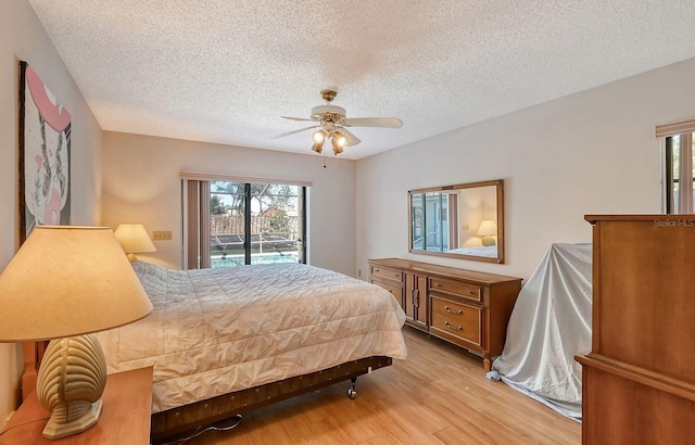 bedroom featuring access to exterior, ceiling fan, light hardwood / wood-style floors, and a textured ceiling