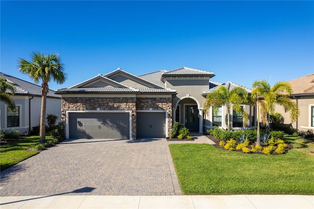 mediterranean / spanish-style home with a front lawn and a garage