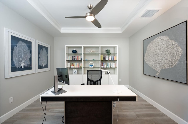 office area featuring light hardwood / wood-style floors, a raised ceiling, ceiling fan, and crown molding