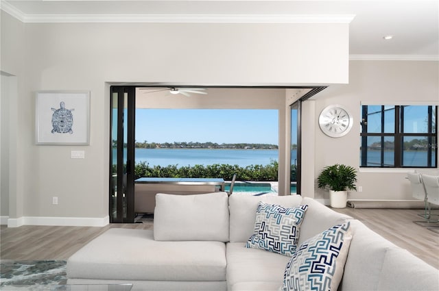 living room featuring ceiling fan, crown molding, a water view, and hardwood / wood-style flooring