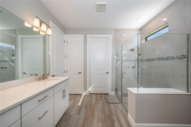 bathroom featuring wood-type flooring, vanity, and a shower with door