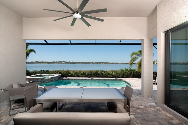 view of swimming pool with ceiling fan, a water view, a patio, and an in ground hot tub