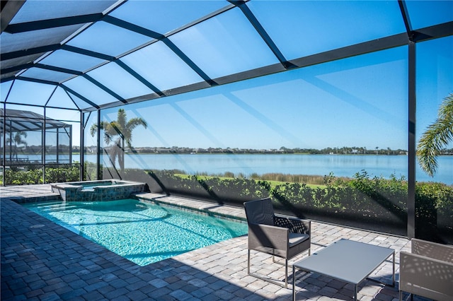 view of pool with an in ground hot tub, a water view, glass enclosure, and a patio area