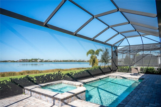 view of pool featuring glass enclosure, an in ground hot tub, a patio area, and a water view